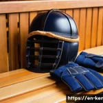 검도 입문을 위한 예산 - A detailed close-up of a high-quality Kendo men (helmet) and kote (gloves) set displayed on a wooden...